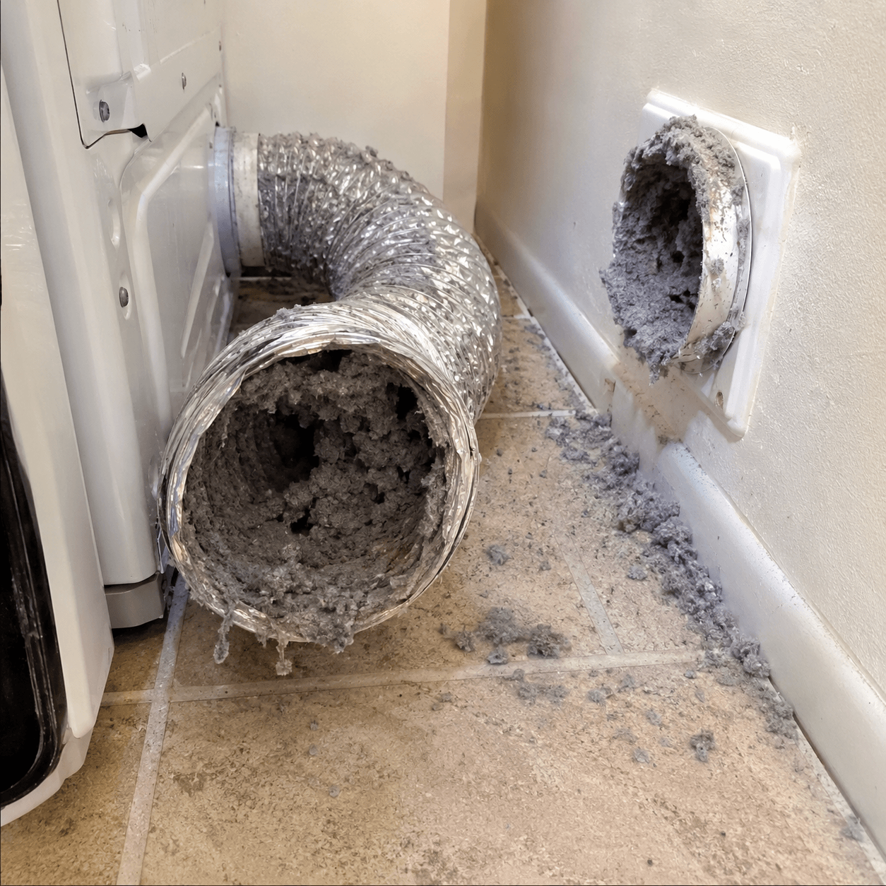 Clogged dryer vent with heavy lint buildup before professional cleaning